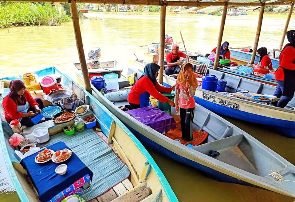 Boat traders selling local foods on a sampan at Suri Island Floating Market (Pasar Terapung Pulau Suri)